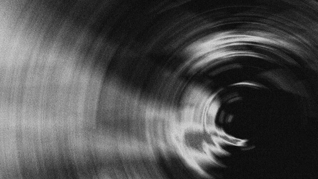 Abstract background with radial motion blur effect in black and white with high contrast with grainy noise effect.