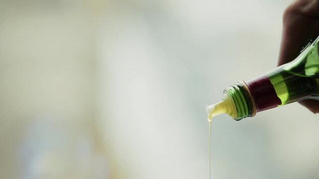 Pouring Extra Virgin Olive Oil From Glass Bottle. Healthy Cooking Ingredient For Salad Dressing