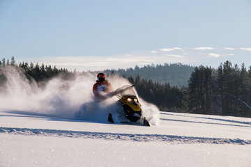 Athlete on a snowmobile moving in the winter forest in the mountains of the Southern Urals