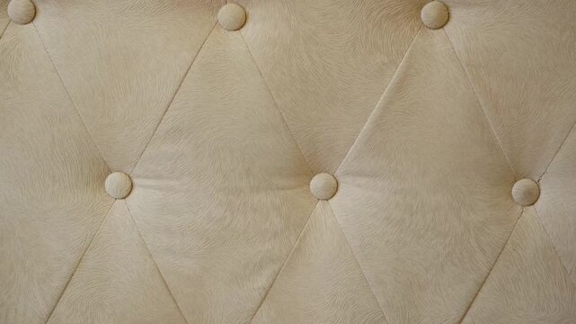 Elegant light beige tufted cotton fabric texture featuring diamond patterns and covered buttons