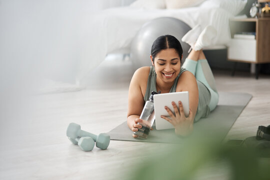 Pilates, smile and tablet with woman on floor in home living room for online fitness class or tutorial. App, exercise and streaming with happy person in apartment for training or workout course