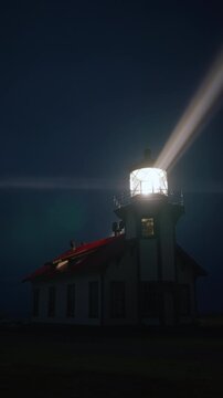 Vertical Screen: Lighthouse beam cutting through dark foggy sky in vertical frame near Mendocino, California, USA creating strong cinematic light rays and moody coastal atmosphere