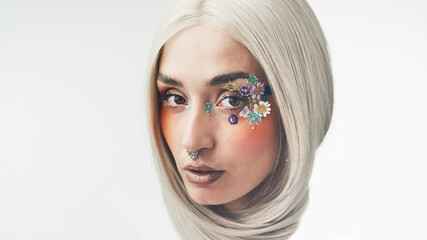 Fototapeta premium Portrait, flowers and woman with makeup in studio, eco friendly beauty or natural spring aesthetic. Space, facial art or person with floral cosmetics for sustainability, nose ring or white background