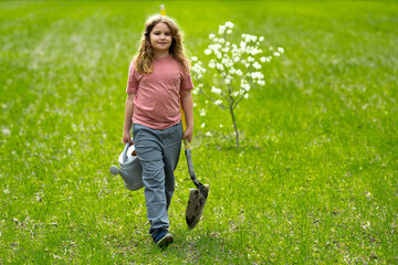 Fototapeta premium Child planting tree outdoors. Spring activity of plant trees. Kid work with shovel and watering can. Kid plant fruit tree. Gardening kids. Kid growth plant and care for tree. Rural kids life. Little