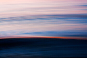 Abstract ocean motion with sunset light streak across wave © Cavan