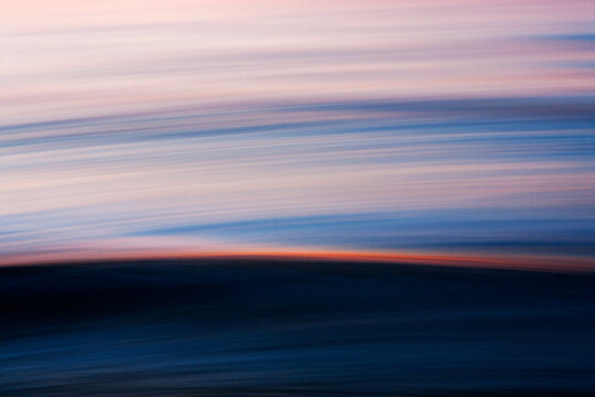 Abstract ocean motion with sunset light streak across wave