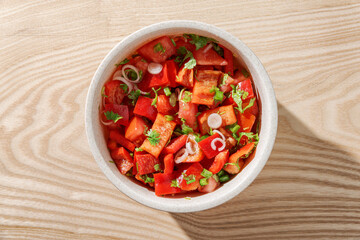Top view of fresh red vegetable bowl on wooden table