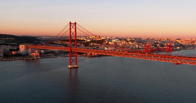 Wide aerial sunset perspective of Lisbon Portugal 25th April red suspension bridge famous iconic landmark