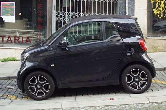 Black Smart Fortwo microcar parked on urban street