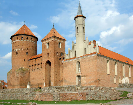 View of the Gothic Reszel Castle with its characteristic round tower. Historical red brick fortification in the town of Reszel, Warmian-Masurian Voivodeship.