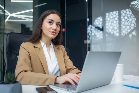 Young businesswoman working at the modern office desk with laptop. look pensive