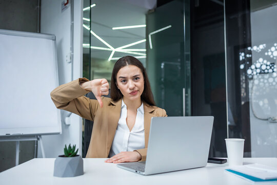 Displeased serious female freelancer woman show thumb down sign gesture, expressing discontent, dissatisfied bad work.