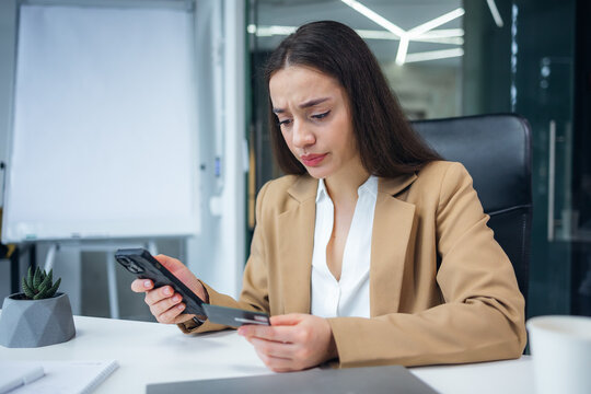 Attractive millennial woman having problems on her mobile banking account, using her internet banking to transfer money.