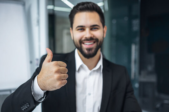 millennial business man happy smiling entrepreneur office manager looking camera smile show thumb up gesture approve recommend like