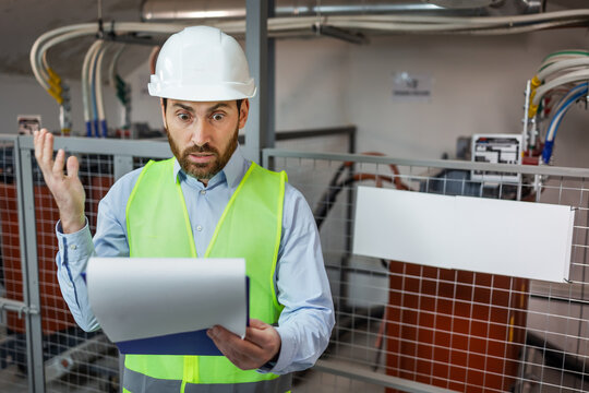 Confused engineering supervisor look on clipboard with shock