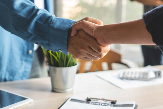 Banker and client hand shaking in office