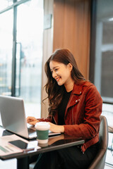 Obraz premium Asian Businesswoman Analyzing Financial Data Reports in Modern Cafe