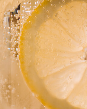 close up macro shot of a lemon in a glass of lemonade