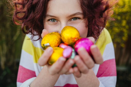 Easter egg hunt, teenage girl holding chocolate eggs