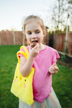 Little girl eating easter chocolate egg, spring holiday