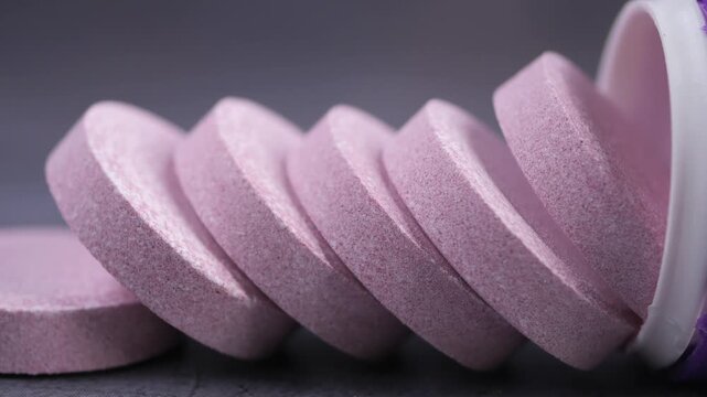 Close up motion of effervescent tablets stacked inside a container.