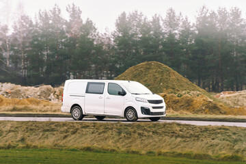 Fototapeta premium White delivery van driving on rural road
