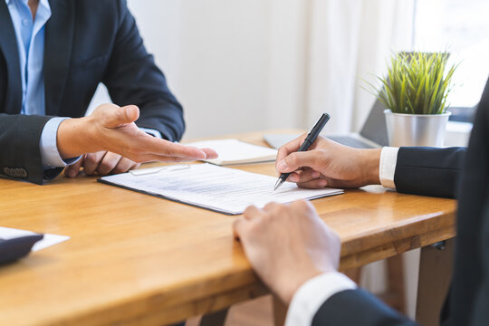 Business finance concept, teamwork and partnership asian businessman customer and salesman discussing client, hand sign sales contract with document at desk office. Lawyers working together at meeting