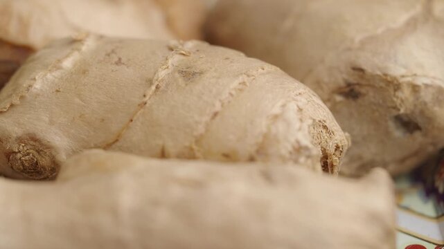 Close up macro shot of fresh ginger root on a decorative surface with golden liquid.