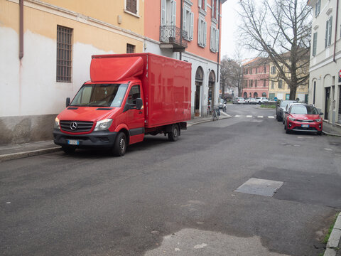 Mercedes Benz Sprinter box van parked on a narrow Italian street in a residential district