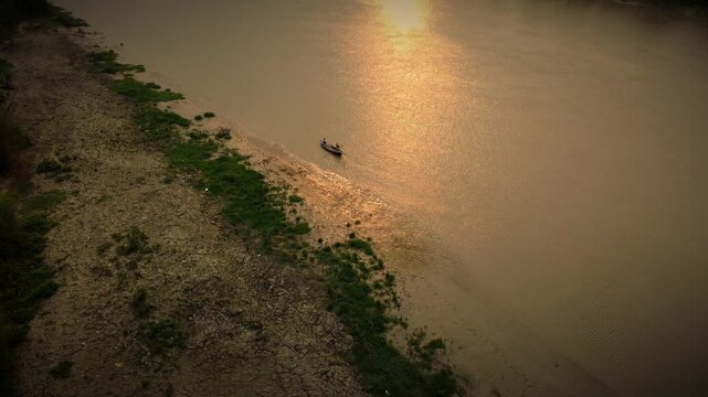 Golden Sunset Over Riverside with Small Boat | Aerial Drone View in Bangladesh 4k