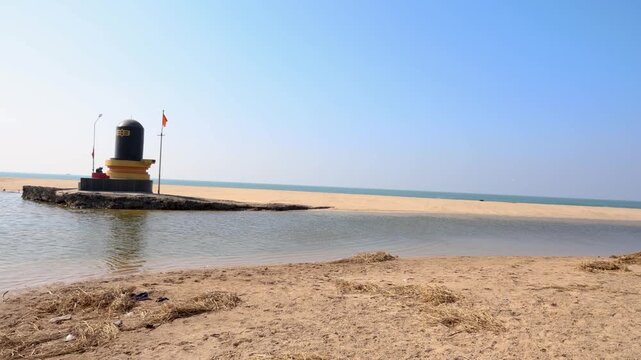 sacred shiva lingam monument standing beside sea under clear sky