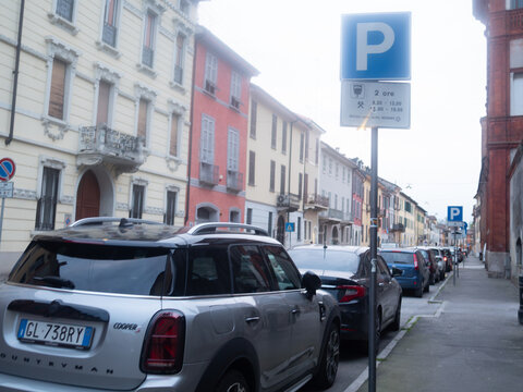 Mini Countryman Cooper S parallel parked on urban street in Italy, regulated by parking sign indicating paid zone
