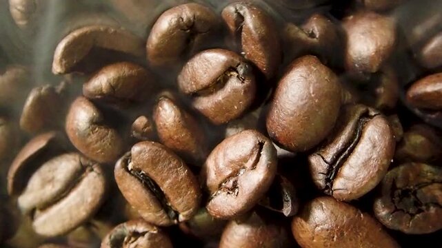 Close up of hot roasted coffee beans with light smoke