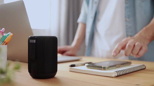 Smart Speaker Virtual Assistant or Artificial Intelligence Concept by Standing Man Connecting Smart Phone with Smart Speaker