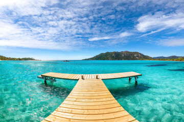 Obraz premium Breathtaking landscape with wooden pier on Santa Giulia beach.
