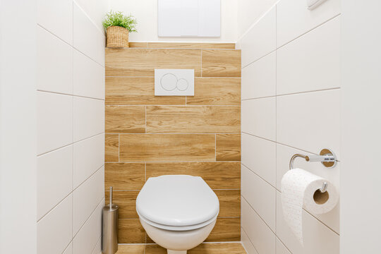 White toilet in a modern minimalist bathroom with wooden wall tiles