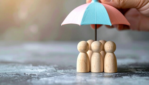 A hand holding an umbrella shielding wooden figures, powerfully symbolizing the concept of collective protection, social security, and essential community support
