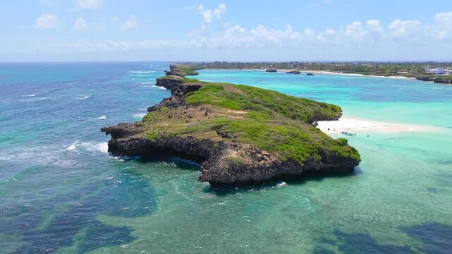 Aerial view of rocky coral islands and turquoise ocean water along the white sand coastline of Watamu Beach, Kenya.
