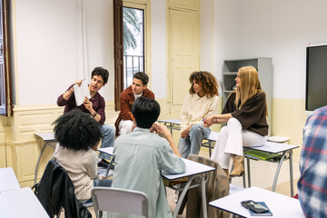 Fototapeta premium Young adults forming a discussion circle, analyzing documents and sharing ideas in a modern learning environment