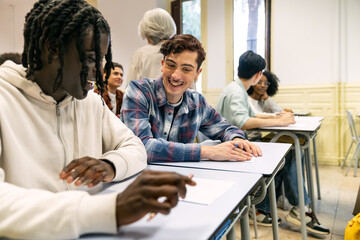 Fototapeta premium Happy multi ethnic students interacting in a classroom setting, enjoying their education and school environment together