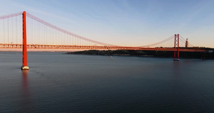 Aerial drone sunset perspective of Lisbon Portugal 25th April red suspension bridge famous iconic landmark
