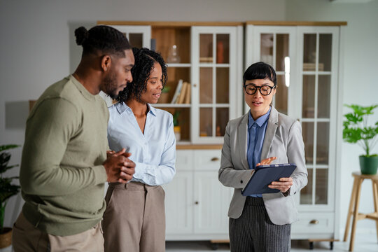 Real estate agent meeting young couple discussing property investment