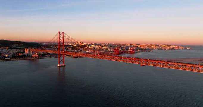 Evening glow on Lisbon Portugal 25th April red suspension bridge famous iconic landmark and river