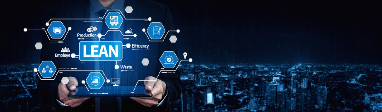 A businessman presents a tablet displaying lean management concepts against a nighttime city backdrop, highlighting efficiency and innovation in modern business practices. Tessel