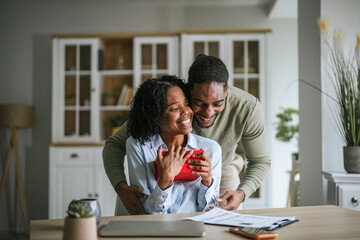 Fototapeta premium Happy couple exchanging gift showing love and appreciation