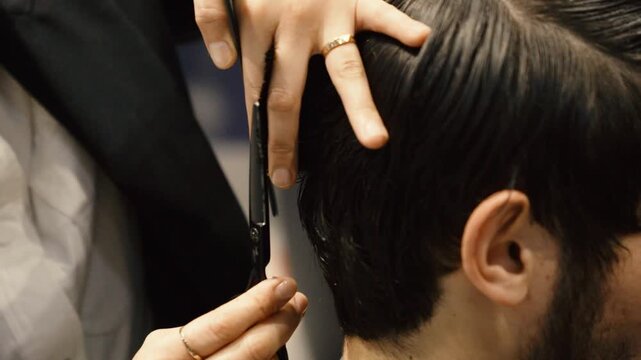 Professional barber cutting male hair with scissors and comb