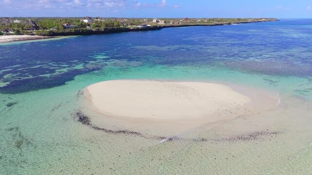 Aerial view of a white sandbar surrounded by turquoise ocean water and coral reefs along the coastline of Watamu Beach, Kenya.