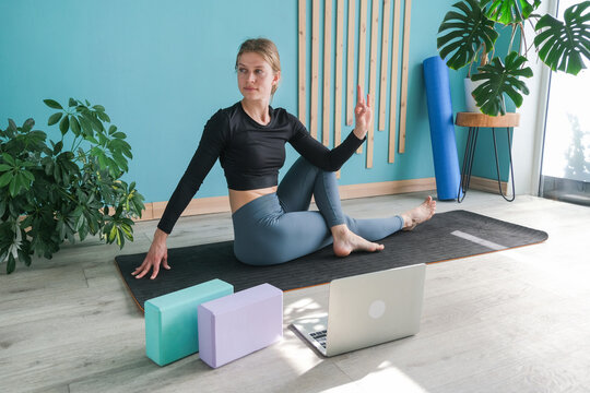 Young attractive woman practicing yoga sitting in Ardha Matsyendrasana