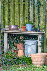 Obraz premium Nature, table and equipment in empty garden for landscape, eco friendly or growth of plants. Botany, outdoor and furniture with flower pots for ecology hobby at park in spring season with greenery.