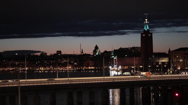 Stockholm, Sweden A night view of the City Hall, Stadshuset, and a busy downtown bridge with traffic in the Slussen district. 
